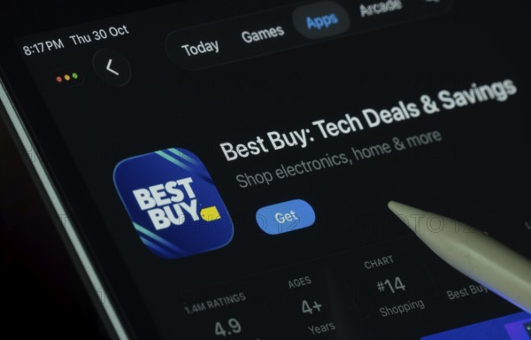 Dhaka, Bangladesh- 30 Oct 2025: Best Buy app displayed on a iPad screen in dark mode with a digital pen pointing at it