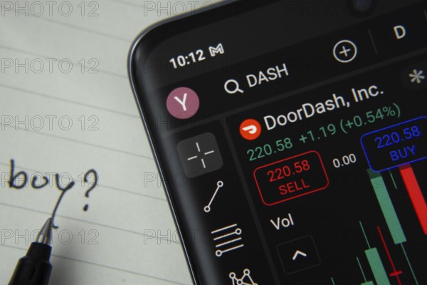 Dhaka, Bangladesh- 20 June 2025: DoorDash stock trading details displayed on smartphone with handwritten note