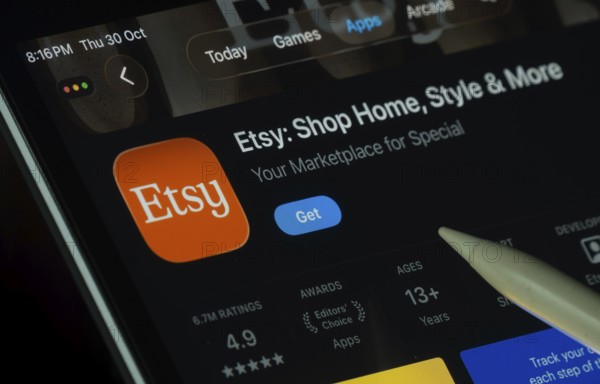 Dhaka, Bangladesh- 30 Oct 2025: Etsy app displayed on a iPad screen in dark mode with a digital pen pointing at it