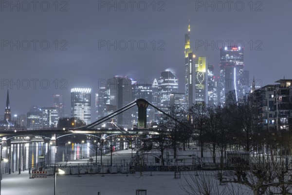 Snowfalls and freezing temperatures have transformed the banks of the Main and Frankfurt banking skyline into a white winter landscape, Frankfurt am Main, Hesse, Germany