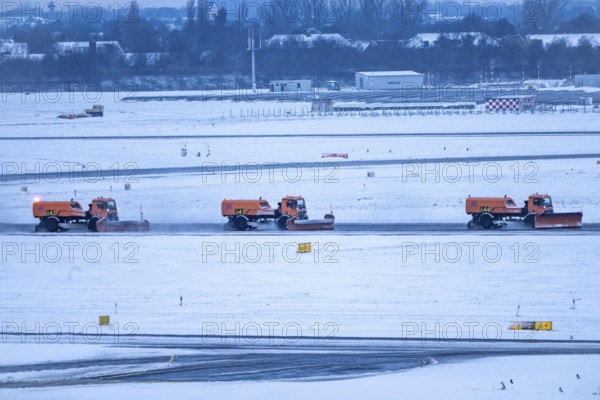 The onset of winter in North Rhine-Westphalia, flight operations are maintained at Düsseldorf Airport with great effort, the taxiways and runway are being freed from snow and ice with many clearing vehicles, North Rhine-Westphalia, Germany