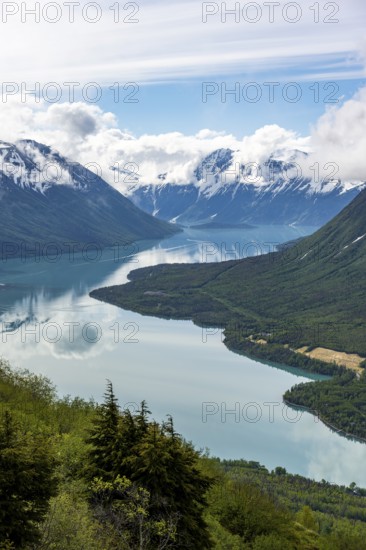 View of snowy mountains in spring and turquoise Kenai Lake with reflection, Slaughter Ridge Trail, Cooper Landing, Kenai Peninsula, Alaska, USA