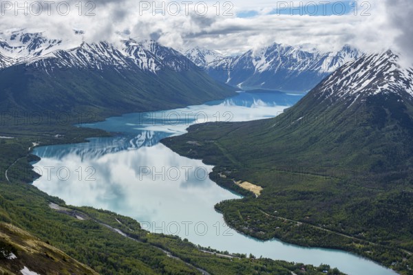 View of snowy mountains in spring and turquoise Kenai Lake with reflection, Slaughter Ridge Trail, Cooper Landing, Kenai Peninsula, Alaska, USA
