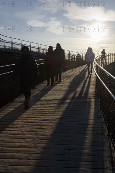 Walkers, tourists on hiking trail, Þingvellir National Park, impressive Almannagja Gorge, Allmännerschlucht, backlight, Golden Circle, Mid-Atlantic Ridge, Iceland