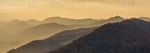View of an autumnal forest from the Gisliflue, behind the Jurassic foothills with the water fluh in the light of the setting sun, Talheim, Canton, Aargau, Switzerland