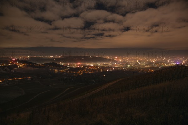 View from Kapellberg near Fellbach across the Neckar Valley to Stuttgart on New Year's Eve from 2025 to 2026. The television tower on the horizon as firecrackers and rockets light up the night sky at the turn of the year and greet the new year