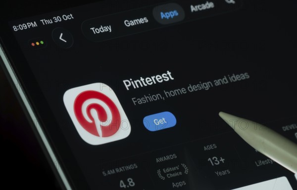 Dhaka, Bangladesh- 30 Oct 2025: Pinterest app displayed on a iPad screen in dark mode with a digital pen pointing at it
