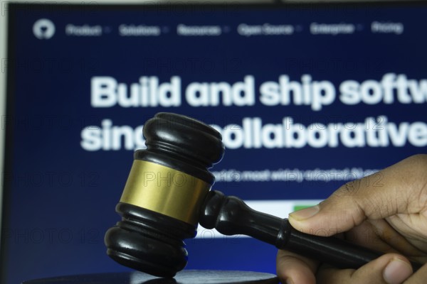 Dhaka, Bangladesh- 20 June 2025: A hand holds a gavel in front of a computer screen displaying GitHub's website