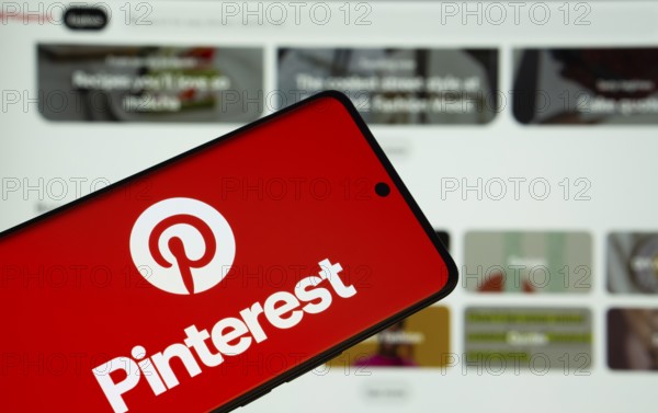 Dhaka, Bangladesh- 05 March 2025: Pinterest logo is displayed on a smartphone screen, with the website visible on a computer screen in the background