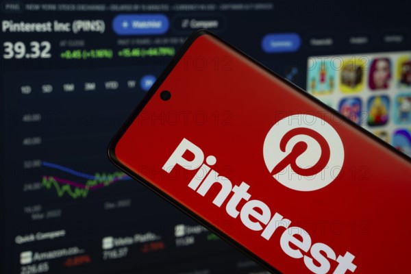 Dhaka, Bangladesh- 5 March 2025: Pinterest logo is displayed on a smartphone screen, with a stock graph webpage visible on a computer screen in the background
