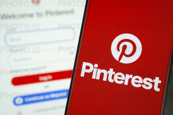 Dhaka, Bangladesh- 05 March 2025: Pinterest logo is displayed on a smartphone screen, with the Pinterest login page visible on a computer screen in the background