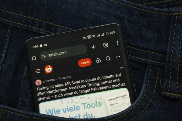 Dhaka, Bangladesh- 15 June 2025: A smartphone displaying the Reddit web interface peeks out of a denim pocket