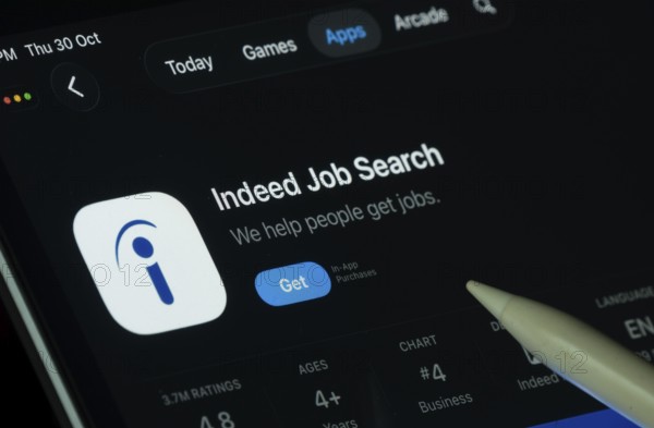 Dhaka, Bangladesh- 30 Oct 2025: Indeed app displayed on a iPad screen in dark mode with a digital pen pointing at it