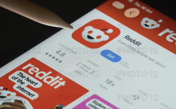 Dhaka, Bangladesh- 30 Oct 2025: Reddit app on a iPad screen with a pen pointing at the install option