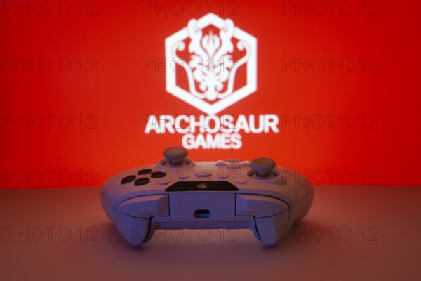Dhaka, Bangladesh- 08 Apr 2025: A gaming controller in front of a Archosaur Games screen