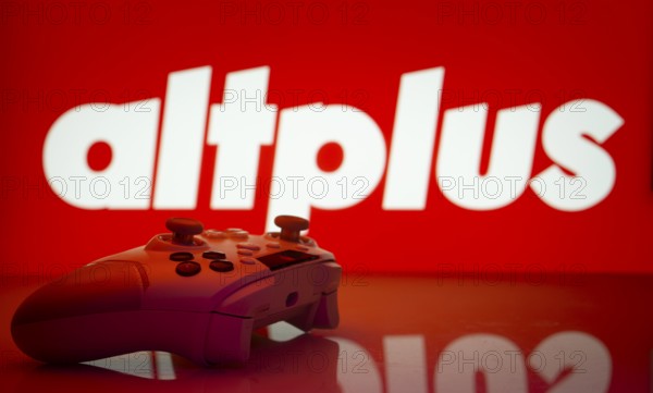 Dhaka, Bangladesh- 20 Mar 2025: A close-up of a white gamepad with the AltPlus Inc seen on screen in the background