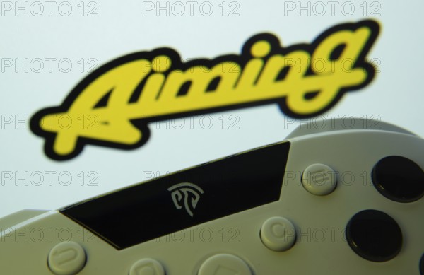 Dhaka, Bangladesh- 24 Mar 2025: A close-up of a gamepad with the Aiming Inc seen on screen in the background