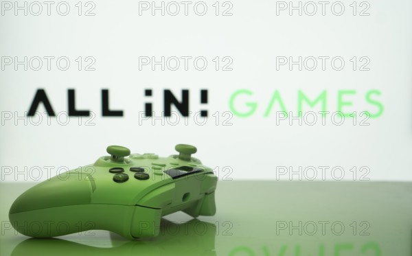 Dhaka, Bangladesh- 20 Mar 2025: A close-up of a white gamepad with the All in! Games seen on screen in the background