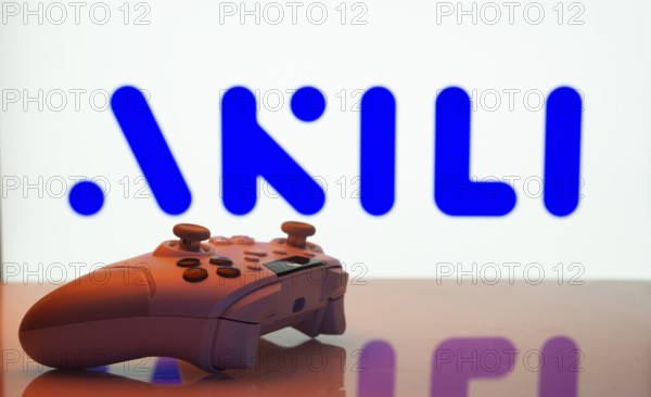 Dhaka, Bangladesh- 20 Mar 2025: A close-up of a white gamepad with the Akili Interactive seen on screen in the background