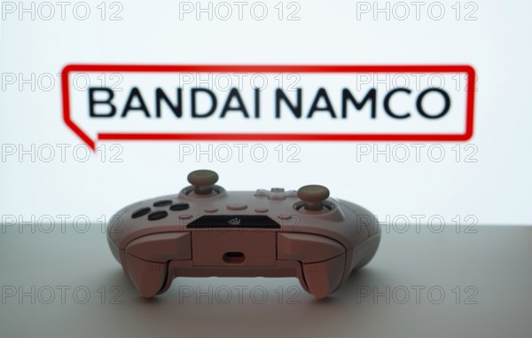 Dhaka, Bangladesh- 08 Apr 2025: A gaming controller in front of a Bandai Namco Entertainment screen