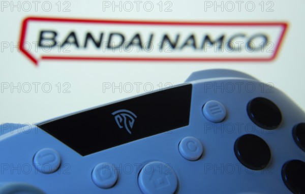 Dhaka, Bangladesh- 24 Mar 2025: A close-up of a gamepad with the Bandai Namco Entertainment seen on screen in the background