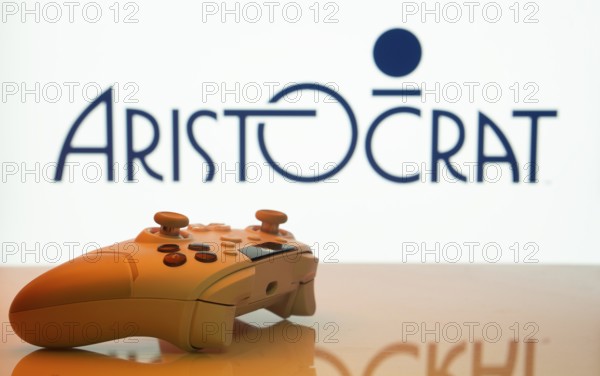 Dhaka, Bangladesh- 20 Mar 2025: A close-up of a white gamepad with the Aristocrat seen on screen in the background