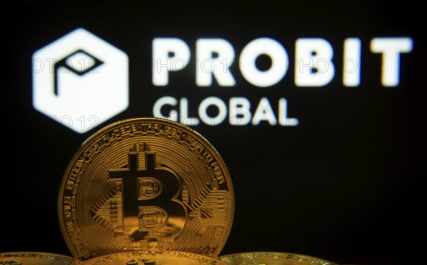 Dhaka, Bangladesh- 27 Mar 2025: Close-up of Bitcoin coins with the ProBit Global logo visible on a screen in the background