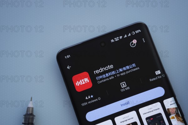 Dhaka, Bangladesh- 29 May 2025: On a blue surface, a smartphone displays the rednote app within the Google Play Store