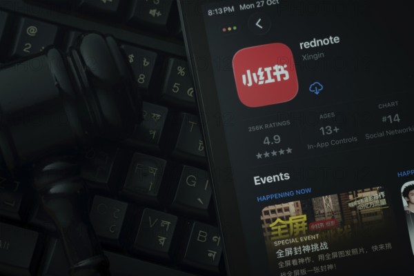 Dhaka, Bangladesh- 28 Oct 2025: An iPad displaying the rednote app against a judge's gavel and dark keyboard background