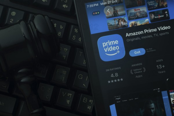 Dhaka, Bangladesh- 28 Oct 2025: An iPad displaying the Amazon Prime Video app against a judge's gavel and dark keyboard background