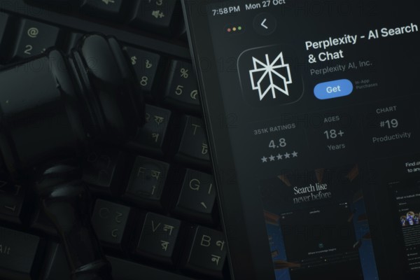 Dhaka, Bangladesh- 28 Oct 2025: An iPad displaying the Perplexity app against a judge's gavel and dark keyboard background