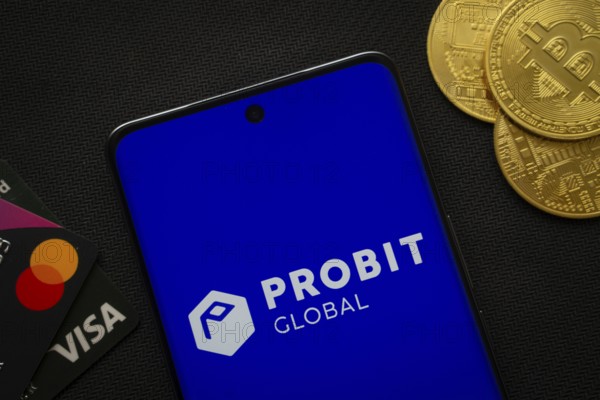 Dhaka, Bangladesh- 26 Aug 2025: Smartphone displaying ProBit Global logo surrounded by Bitcoin coins and payment cards