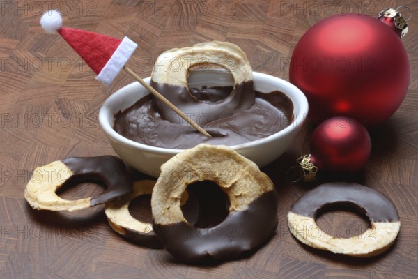 Apple rings, coated with chocolate, chocolate glaze in bowl
