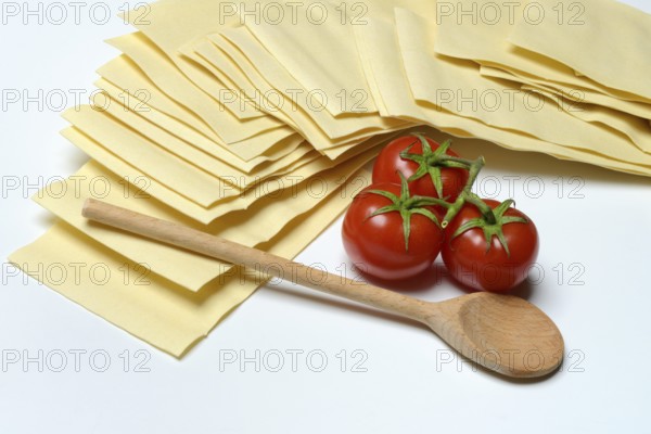 Lasagna, dried lasagna leaves with tomatoes and cooking spoon