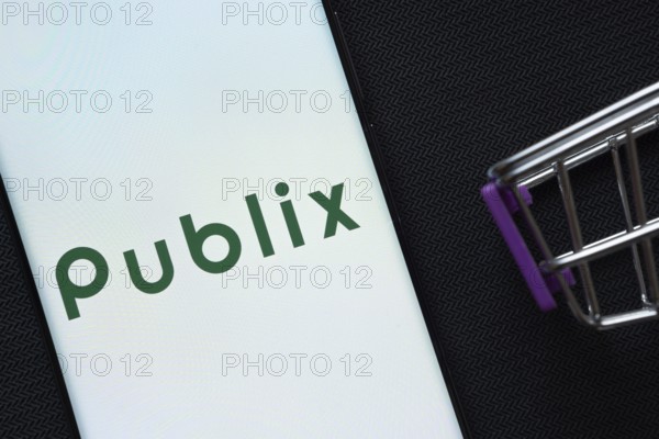 Dhaka, Bangladesh- 03 July 2025: A smartphone displaying the Publix logo next to a miniature shopping cart on a background