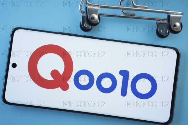 Dhaka, Bangladesh- 03 July 2025: Smartphone screen showing the Qoo10 logo with shopping cart wheels on a blue background