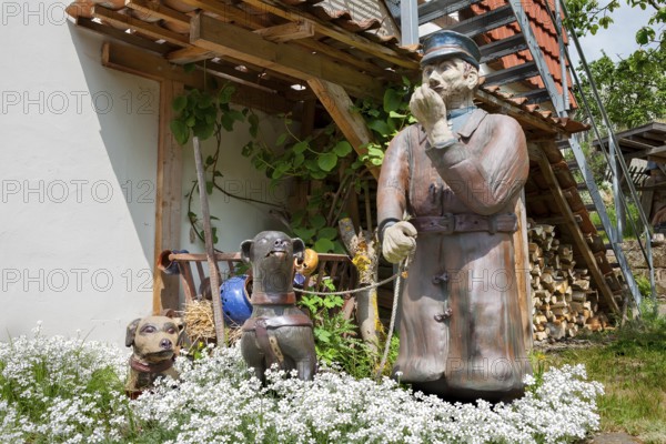 A man with dogs as a ceramic figure stands in front of the Keramik.um, an exhibition house dedicated to the history of Fredelsloh's pottery trade, Fredelsloh, Lower Saxony, Germany