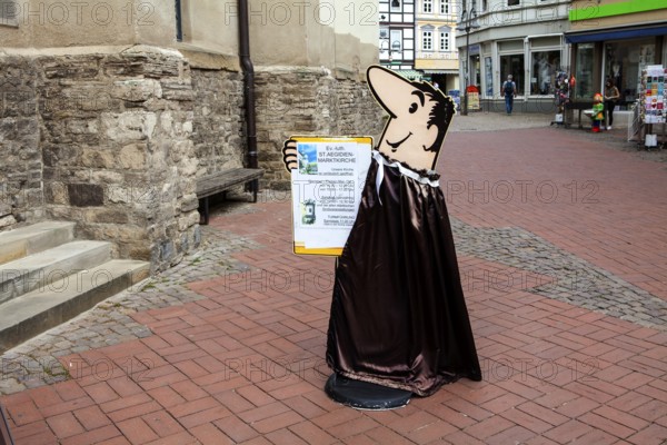 Bruno, the HB-Männchen or HB Man, a cartoon character from German commercial television advertised the HB cigarettes, information sign in front of market church St. Aegidien or Saint Giles, Osterode, Upper Harz region, Lower Saxony, Germany