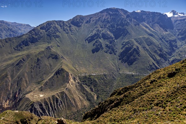 Extensive mountain landscape with a deep gorge, overgrown and under clear skies, The landscape of Colca Canyon in the Aden of Peru