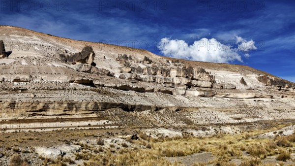 Stratified rock formations with blue sky and sparse clouds, The Andean highlands of Peru