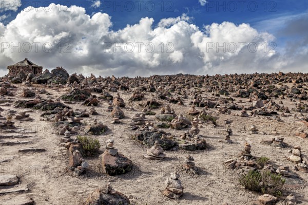 Barren hilly landscape with stone clusters under a cloudy sky, The Andean highlands of Peru