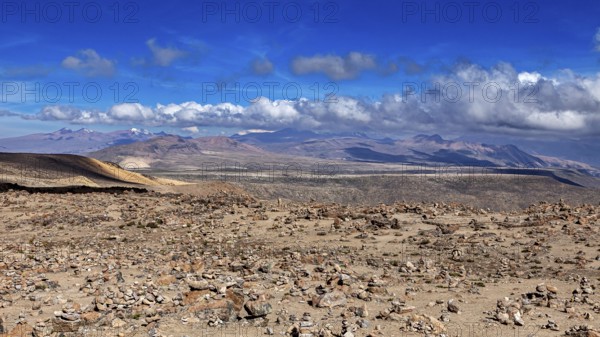 Stone area under blue sky with rising clouds in the distance, The highlands of the Andes of Peru