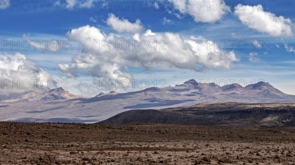Barren landscape with mountains in the background and scattered clouds in the sky, The highlands of the Andes of Peru
