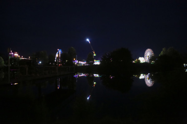 Fairground in Ulm Friedrichsau at night, folk festival, hustle and bustle, fair, Ferris wheel, amusement park, amusement attraction, ride, artificial light, darkness, reflection in natural lake, Ausee, Ferris wheel, Ulm, Baden-Württemberg, Germany