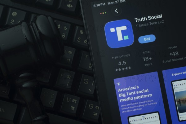 Dhaka, Bangladesh- 28 Oct 2025: An iPad displaying the Truth Social app against a judge's gavel and dark keyboard background