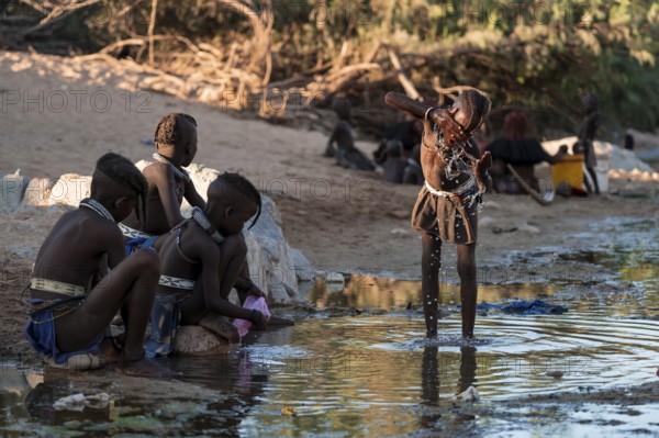 Himba child washing with water on a river, traditional Himba, Kaokoveld, Kunene, Namibia