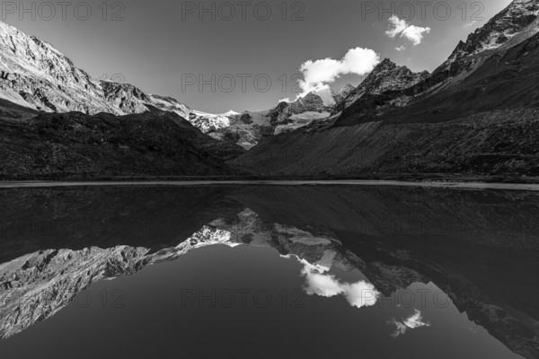 The Moiry glacier and mountain peaks are reflected in Lac de Chateaupre, black and white photo, Val d'Anniviers, Valais Alps, Canton of Valais, Switzerland
