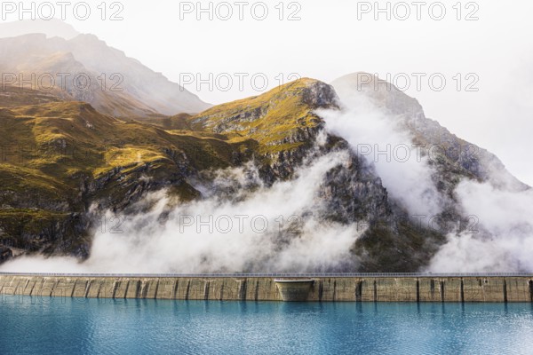 Fog rises over the dam of the Lac de Moiry Reservoir, Val d'Anniviers, Valais Alps, Canton of Valais, Switzerland