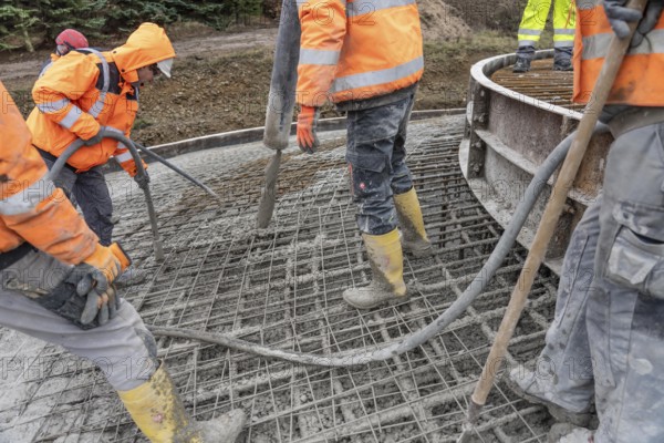 Concreting, concreting the foundation of a wind turbine, more than 600 cubic meters of concrete will be pumped into the foundation for over 7 hours, over 100 tons of reinforcing steel have been used, the wind turbine will have a hub height of 160 meters, part of a new wind farm in Sauerland, near Balve, North Rhine-Westphalia, Germany