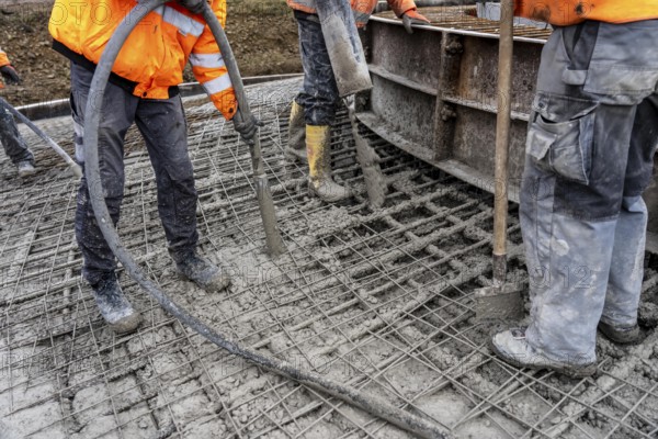 Concreting, concreting the foundation of a wind turbine, concrete pump hose, compressor, more than 600 cubic meters of concrete will be pumped into the foundation for over 7 hours, over 100 tons of reinforcing steel have been used, the wind turbine will have a hub height of 160 meters, part of a new wind farm in Sauerland, near Balve, North Rhine-Westphalia, Germany